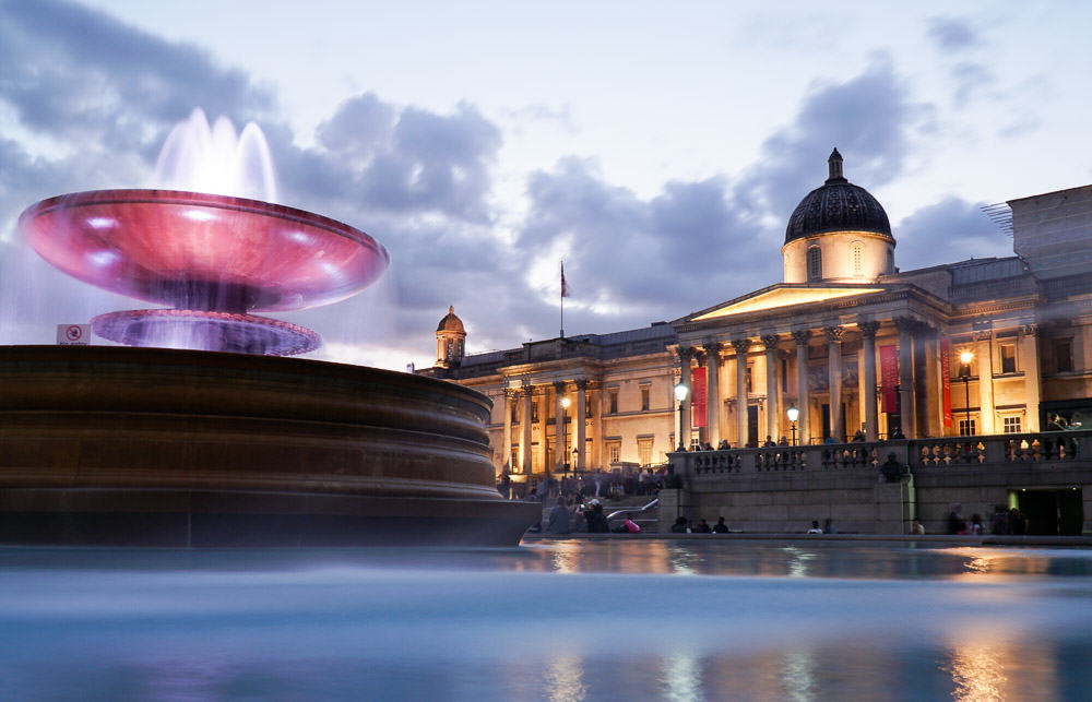 Trafalgar Square fountain at night - London Budget Guide
